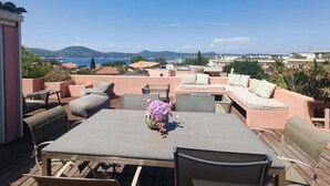 Une terrasse sur le toit, avec une table, des chaises et un arrangement floral.