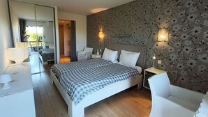 Une chambre à coucher moderne avec un grand lit, des tables de chevet, un bureau et une chaise.