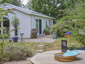 A house with a garden, a wooden deck, and a sign that reads 'villa for you'. - Beautiful chalet in the middle of the forests (Garderen)