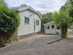 A two-story building with a brick pathway leading to the entrance. - Beautiful chalet in the middle of the forests (Garderen)