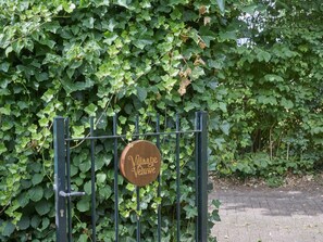 Ein Metalltor mit einem Holzschild, auf dem 'Villaage Vellew' steht.