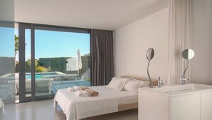 Quarto moderno com uma cama grande, banheiro separado com banheira e vista para uma piscina.