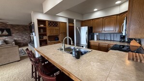 Una cocina moderna con una isla central, armarios de madera y un refrigerador integrado.