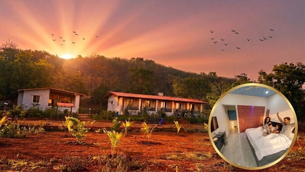 A hotel with a red-roofed building, a visible guest room with a bed and a person sitting on it, and a view of the sunset with birds flying in the sky. - Beaches & Hills Resorts (Shrivardhan)