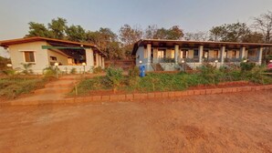 Um edifício de dois andares com varanda e degraus que levam à entrada.