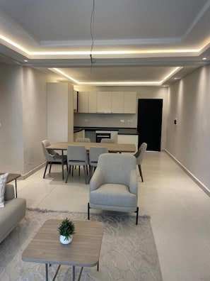 A modern interior with a dining area, a sofa, and a coffee table. - Tanji Cliffs (Tanji)