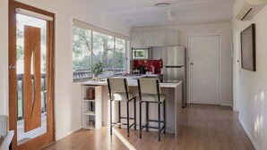 A compact kitchen with a refrigerator, microwave, and bar stools. - Stewie's Nest - Port Arthur Shack with fire pit (Tasman)