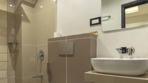 A modern bathroom with a toilet, sink, and shower. - GRAND HOTEL ANNEX (Aizawl)