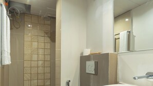 A modern bathroom with a toilet, sink, and shower.