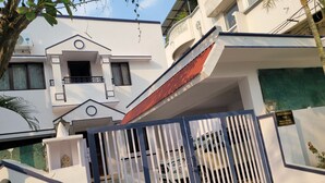 Il s’agit d’un immeuble résidentiel fermé, avec une façade blanche, un toit rouge et une porte de garage bien visible.