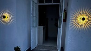 Portaat johtavat pimeään sisätilaan, ja molemmilla puolilla on seinälle asennettuja, kuvioituja valaisimia.