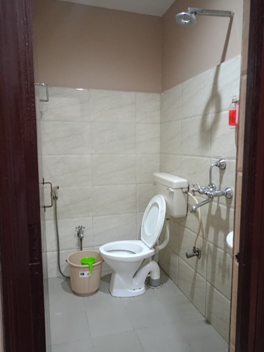 A small, private bathroom with a toilet, bidet, and shower.