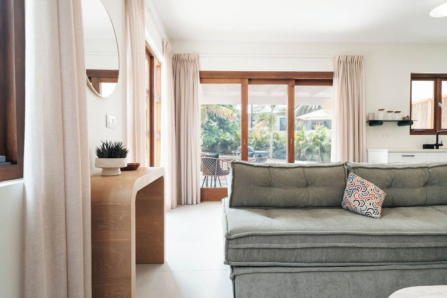 Een moderne woonkamer met een bank, een eethoek en uitzicht op de omgeving.