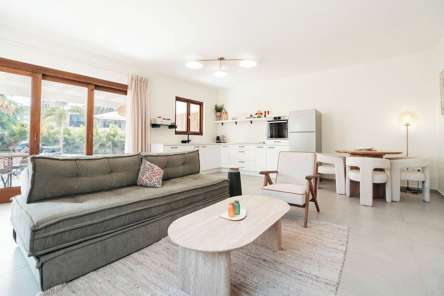 Un salon moderne comprenant un canapé, une table basse et un coin repas avec des chaises et une table.