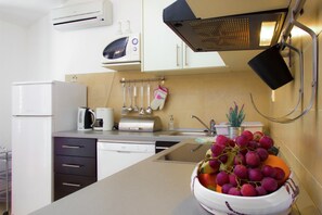 Eine moderne Küche mit Mikrowelle, Toaster und Spüle. Auf der Arbeitsfläche steht eine Schale mit Obst.