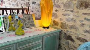 A stone wall, a teal cabinet with drawers, and a yellow lamp. - QUIET LOFT IN THE COUNTRYSIDE, 7 KM FROM AMENITIES (Saint-Bressou)