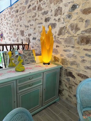 A stone wall, a teal cabinet with drawers, and a yellow lamp. - QUIET LOFT IN THE COUNTRYSIDE, 7 KM FROM AMENITIES (Saint-Bressou)