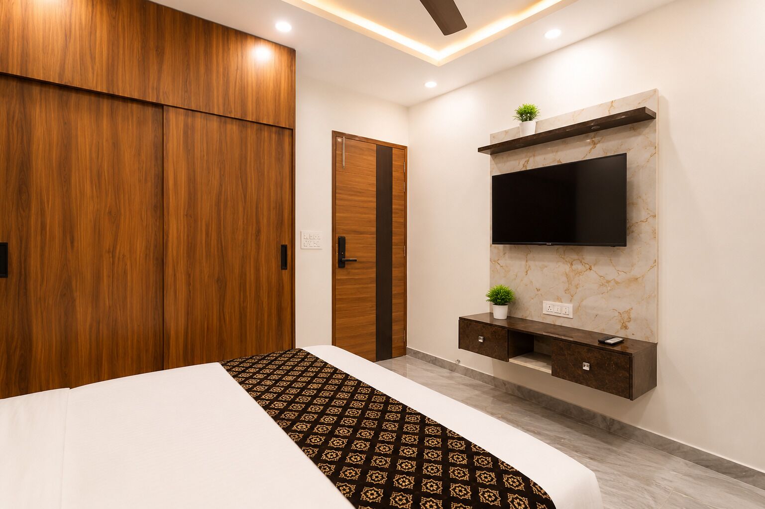 A bedroom with a bed, wardrobe, TV, and a small plant.