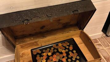 An open wooden chest filled with coins.