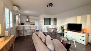 Ein modernes Wohnzimmer mit einer Couch, einem Fernseher und einem Glastisch.