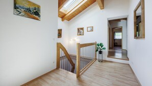 A spacious interior with a wooden staircase, a skylight, and a painting on the wall. - Hinterseer Vacation Home (Ruhpolding)