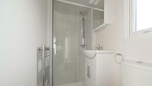A bathroom with a shower, toilet, sink, and a glass-enclosed shower stall. - Holiday Home in Linden With Terrace (Linden)