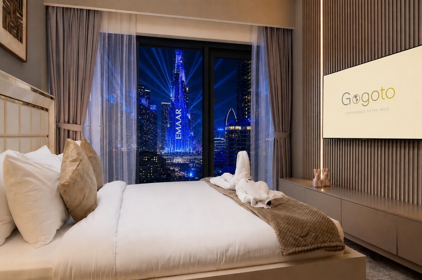 Une chambre d’hôtel avec un lit, une vue sur le paysage urbain et un écran affichant le nom de l’hôtel.