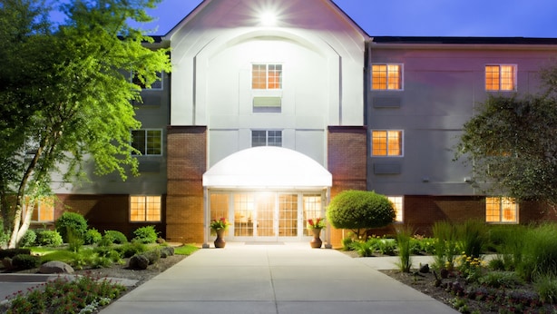 A multi-story hotel with a prominent entrance, a covered porch, and a landscaped garden.