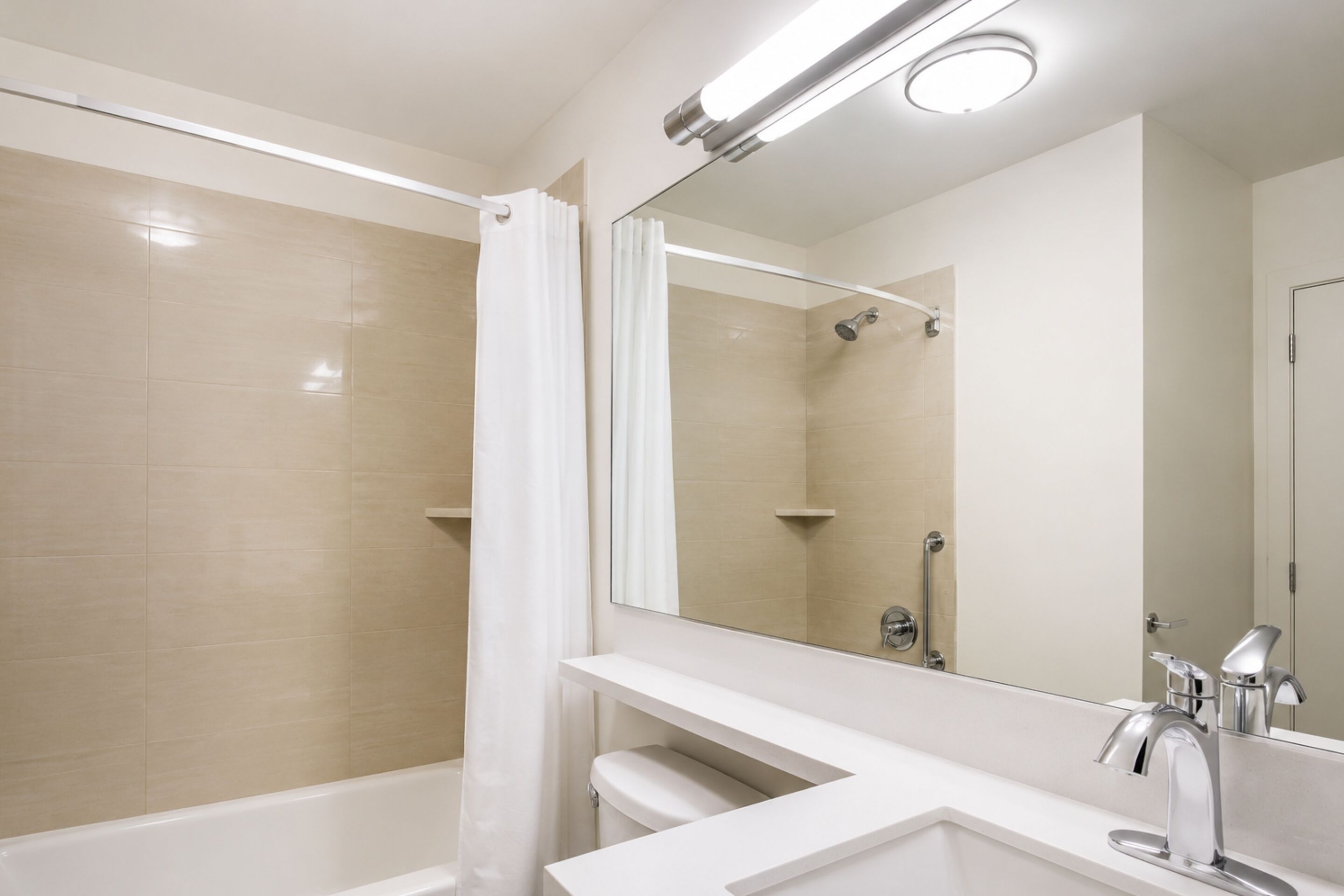 A modern bathroom with a shower, toilet, and sink.