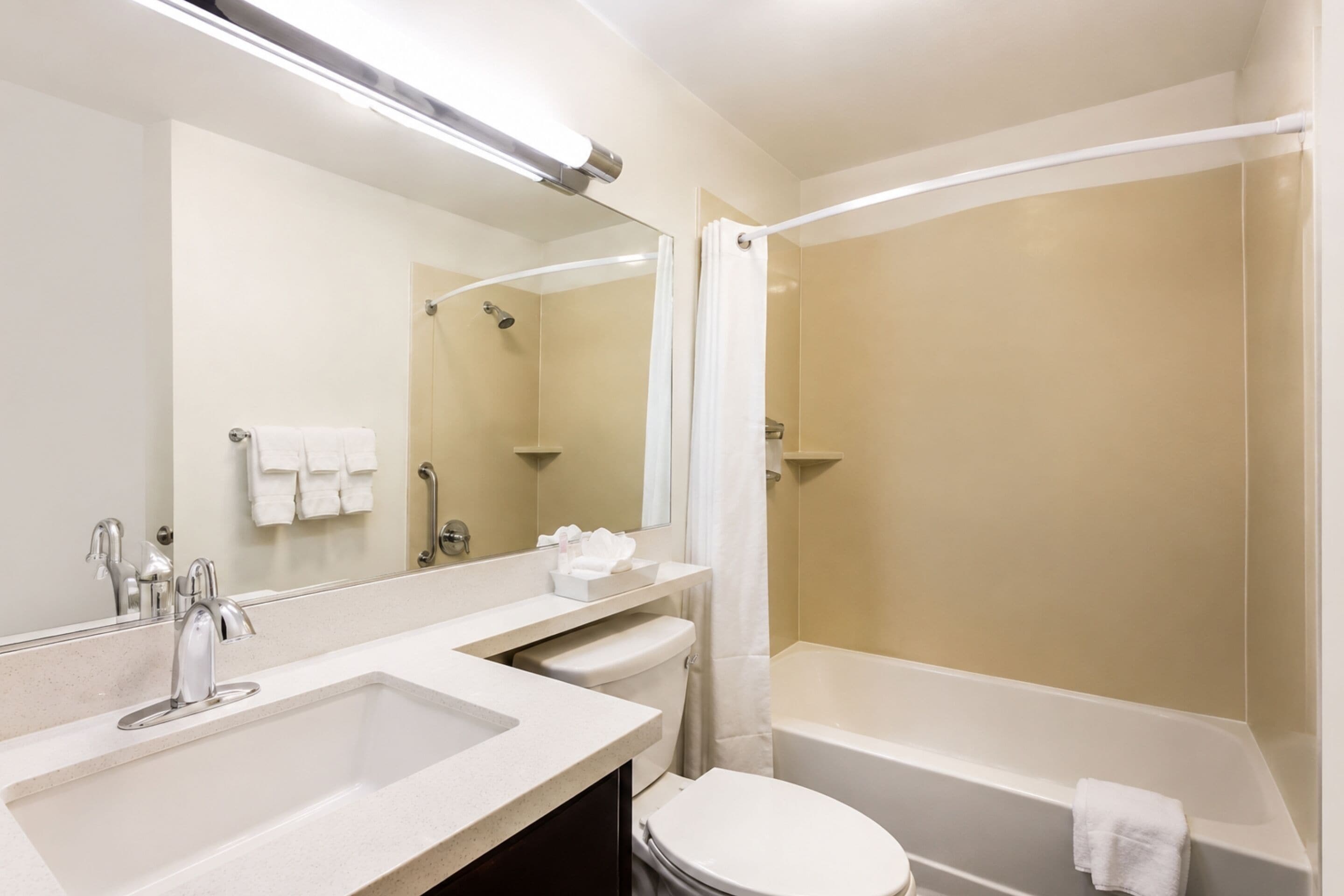 A modern bathroom with a sink, toilet, and bathtub.