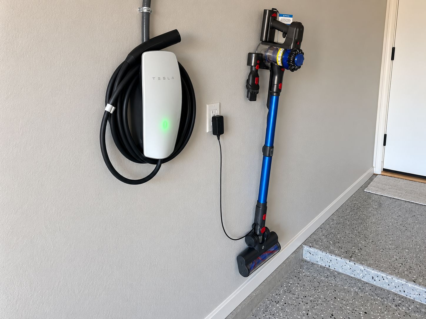 A Tesla charging station with a vacuum cleaner.