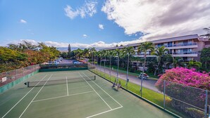 An outdoor tennis court with a net, surrounded by a fence and palm trees. - 2 2 New Designer Beachside Resort Vistas (Kihei)