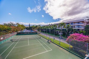 An outdoor tennis court with a net, surrounded by a fence and palm trees. - 2 2 New Designer Beachside Resort Vistas (Kihei)