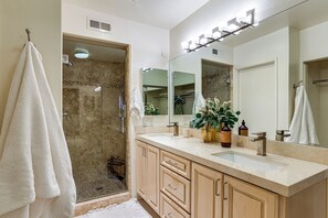 A bathroom with a shower, a sink, and a large mirror. - Private Hot Tub + Rooftop Patio: Palm Desert Oasis (Palm Desert)