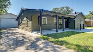 Une maison de plain-pied avec un porche abrité, un garage et une pelouse bien entretenue.