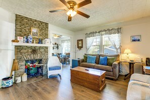A living room with a stone fireplace, a ceiling fan, a sofa, and a coffee table. - Balcony w/ Stunning View! Lake Junaluska Retreat (Lake Junaluska)