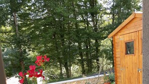 A wooden shed with a window, surrounded by a garden with gravel paths and potted plants. - Le Val du Loup Bed and Breakfast: Continental breakfast available upon request (Sanilhac)