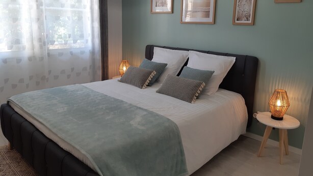 A bedroom with a bed, bedside lamps, a window with curtains, and framed pictures on the wall. - Le Val du Loup Bed and Breakfast: Continental breakfast available upon request (Sanilhac)