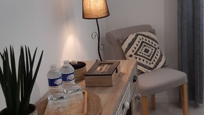 A modern living room with a wooden desk, a television mounted on the wall, a lamp, a chair, and a patterned rug. - Le Val du Loup Bed and Breakfast: Continental breakfast available upon request (Sanilhac)