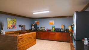 Un coin cuisine doté de plans de travail en bois, d’une machine à café, d’un four à micro-ondes et d’un réfrigérateur.
