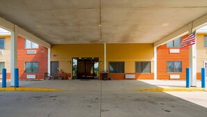 Une station-service dotée d’une entrée abritée, de bornes bleues et d’un drapeau américain.