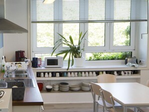 Eine moderne Küche mit Fenster, einer Mikrowelle, einem Spülbecken und einem Essbereich.