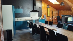 A modern kitchen with a dining area, wooden ceiling, and a TV. - La Canissa Carrada Vacation Rental for 4 to 6 People (Chaspuzac)
