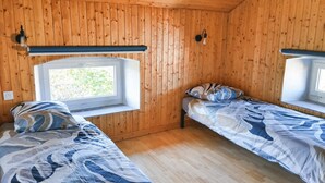 A cabin with two beds, wooden walls, a window, and a light fixture. - La Canissa Carrada Vacation Rental for 4 to 6 People (Chaspuzac)