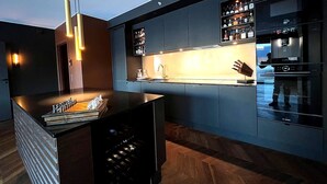 A modern kitchen with a built-in wine cooler, a bar area, and a Bosch refrigerator.