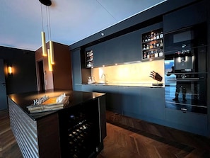 A modern kitchen with a built-in wine cooler, a bar area, and a Bosch refrigerator.