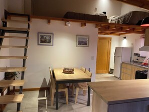 Eine kleine Küche mit Kühlschrank, Herd und Holzschränken.