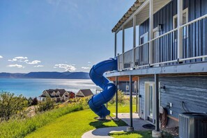Ein modernes Haus mit einer einzigartigen blauen Spiralrutsche, einem Balkon und Blick auf den Ozean.