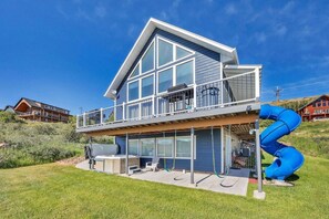 Ein zweistöckiges Haus mit Balkon, Whirlpool und einer blauen Rutsche.