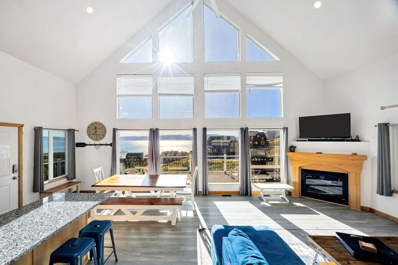 Un loft espacioso con techo alto, ventanas grandes, zona de comedor, sala de estar con sofá y chimenea.